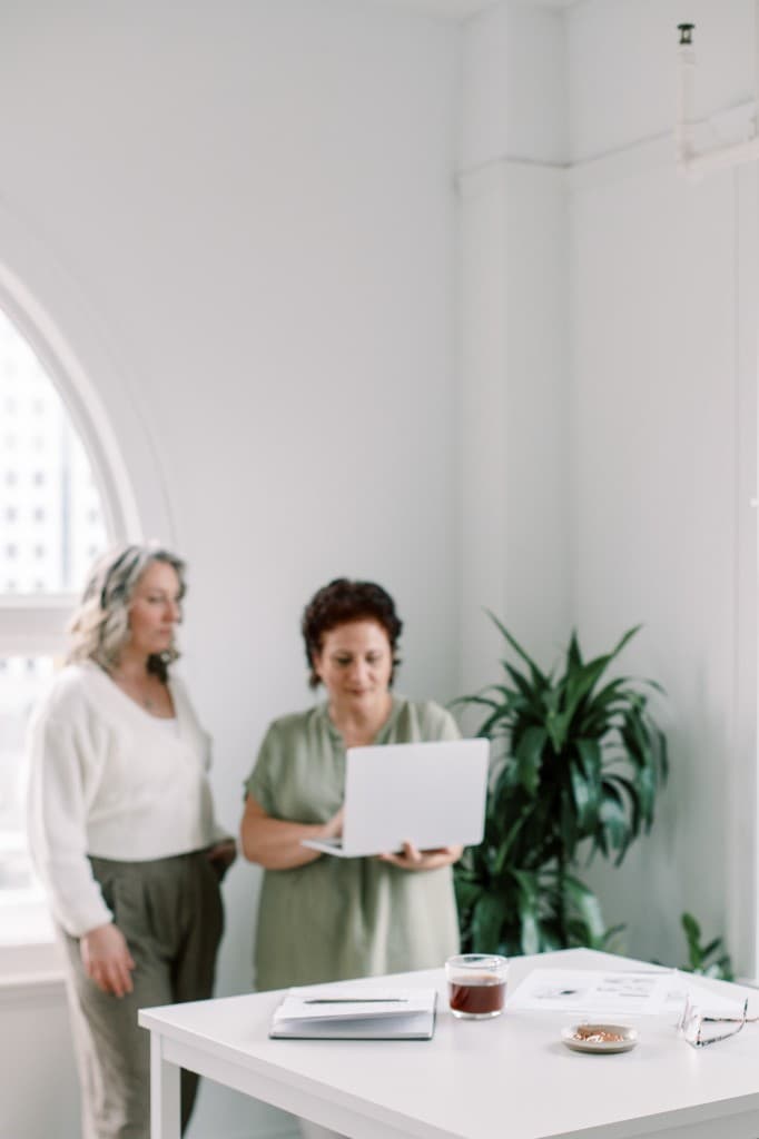 Two founders reviewing work together at a bright desk