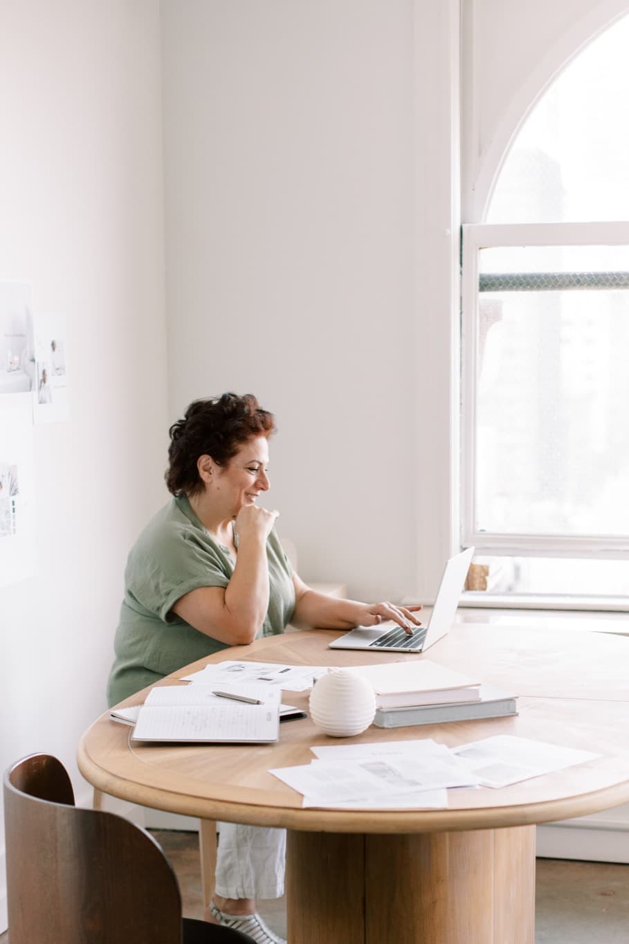 Founder working at a bright desk with a laptop